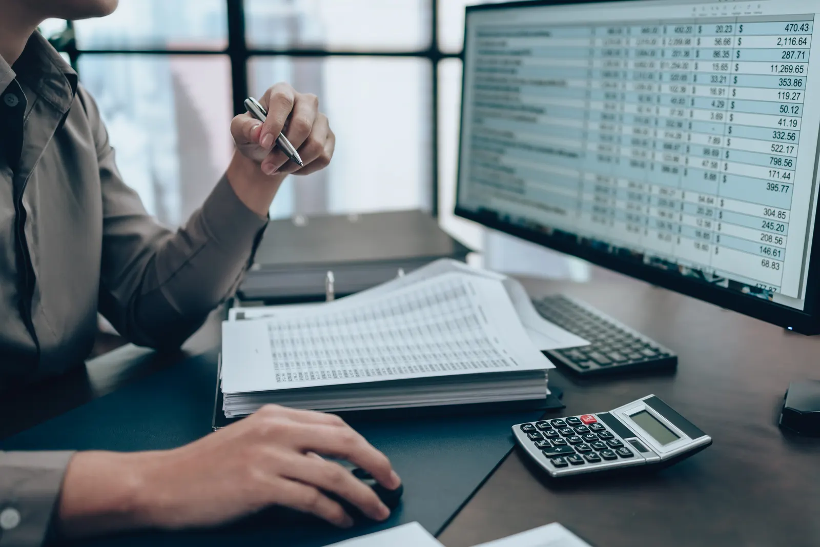 Accountant reviewing spreadsheets and financial statements at a desk in Hobart